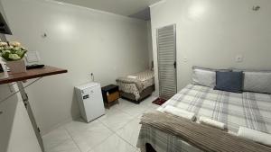 Un dormitorio pequeño con una cama y un refrigerador. en Aconchego Hospedagem, en Barreirinhas