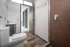a bathroom with a toilet and a glass shower at Casa Adul Chignahuapan in Chignahuapan +35 photos