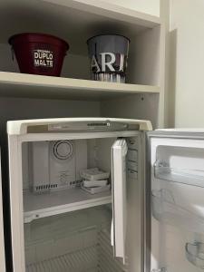 a refrigerator with its door open in a kitchen at Águas da Serra Apto 728A in Rio Quente +49 photos