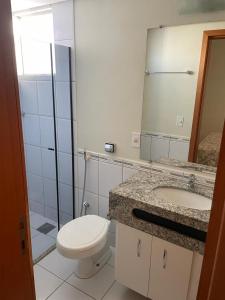 a bathroom with a toilet and a sink and a mirror at Águas da Serra Apto 728A in Rio Quente