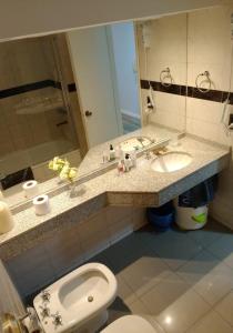 une salle de bain avec un lavabo, des toilettes et un miroir dans l'établissement Monoambiente Centrico, à Córdoba