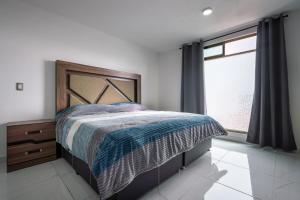 a bedroom with a bed and a window at Casa Adul Chignahuapan in Chignahuapan