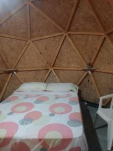 a room with a bed and a chair in a yurt at EL ENCUENTRO Domo Geodesico in Miramar