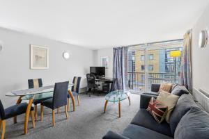 a living room with a couch and a table at Ensuite Room in Canary Wharf with attached Bathroom in London