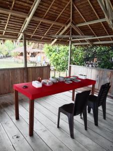 a red table and chairs on a wooden deck at Famwall Homestay Raja Ampat in Keruo