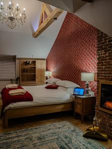a bedroom with a large bed and a brick wall at Lovelace Suites by Threads of Time Hotel Bruges in Bruges