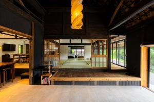 a living room with a large room with glass doors at OMOYA総領 時を紡ぐ茅葺きの宿 - Thatched inn that spins time - Supported by COCOSTAY in Shōbara