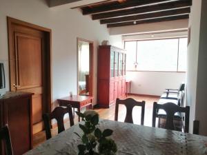 a dining room with a table and chairs and a window at Casa de Rosita in Quito +6 photos