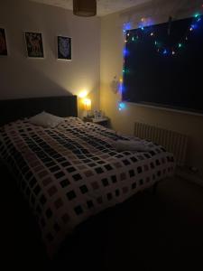 a bedroom with a bed and a window with blue lights at Kilverston in Peterborough