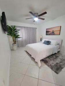Un dormitorio con una cama y un ventilador de techo. en My Tropical Paradise with pool in Miami, en Tamiami