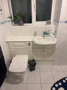 a white bathroom with a toilet and a sink at Kilverston in Peterborough