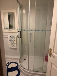 a shower with a glass door in a bathroom at Kilverston in Peterborough