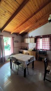 a kitchen with a table in the middle of a room at Tintes de otoño in Mina Clavero