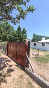 a fence with a wooden gate in a field at Tintes de otoño in Mina Clavero