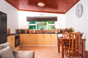 a kitchen with a table and a clock on the wall at Mindful Escape Cottage in Heathfield