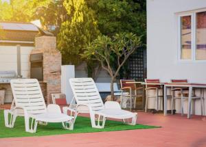 two white chairs and a table and some tables and chairs at Mindful Escape Cottage in Heathfield