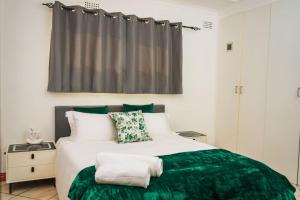 a bedroom with a large bed with a green blanket at Mindful Escape Cottage in Heathfield +12 photos