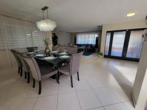 Un comedor con una mesa y sillas negras. en My Tropical Paradise with pool in Miami, en Tamiami