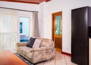 a living room with a couch and a refrigerator at Mindful Escape Cottage in Heathfield