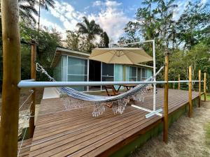 a hammock on the deck of a house at suíte Saíra in Ubatuba