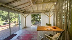 a dining room with a wooden table and a large window at suíte Saíra in Ubatuba