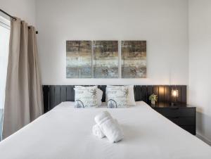 a bedroom with a white bed with towels on it at Toca - Jacuzzi - Heart of Old Town in Scottsdale +51 photos