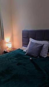 un letto con testiera blu e un cuscino sopra di Refúgio Vida & Brisa a Pelotas