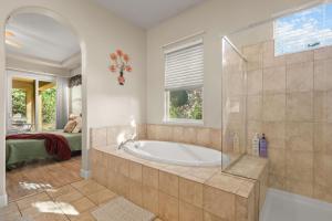 a large bathroom with a tub and a bedroom at The Rivercrest Branch House - Close to Costco, Boat Ramp, Fishing, and Shopping in Redding +41 photos