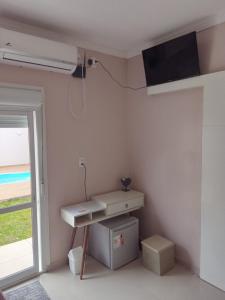 una stanza con una scrivania e una finestra di Suíte Master a Frederico Westphalen