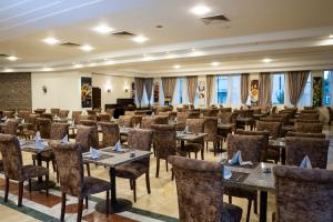 a conference room with tables and chairs and a stage at Dexon Roma All Inclusive Hotel in Hurghada