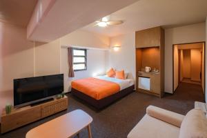 a hotel room with a bed and a flat screen tv at Miyazaki Mango Hotel - Vacation STAY 58303v in Miyazaki