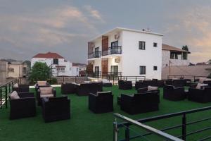 a group of chairs sitting on the grass in front of a building at Chamis Suites in Bijilo