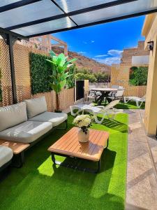 a patio with a couch and a table on grass at La huerta centro in Alicante