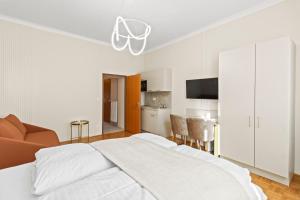 a white bedroom with a large bed and a kitchen at 1 Min to U6 Niederhofstraße I Near Schönbrunn in Vienna +27 photos