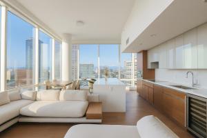Una sala de estar con un sofá blanco y grandes ventanales. en Skyline Serenity Penthouse, en Los Ángeles