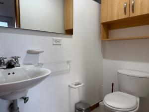 a white bathroom with a sink and a toilet at Countryside apartment in Rionegro