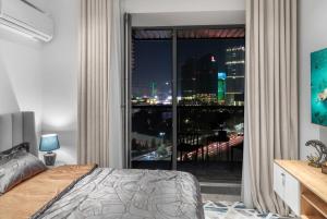 a bedroom with a large window with a city view at Urban Luxe U-Tower Tashkent City View Apartment in Tashkent