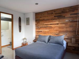 a bedroom with a wooden accent wall and a bed at Countryside apartment in Rionegro