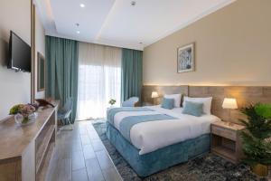 a hotel room with a large bed and a desk at Hotel 21 Makkah in Makkah