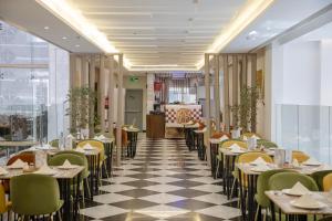 a restaurant with tables and chairs on a checkered floor at Hotel 21 Makkah in Mecca