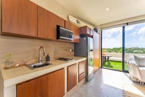 una cocina con armarios de madera y una gran ventana en Private Jacuzzi, Starlink, Golf-View Terrace - Puerto Aventuras, en Puerto Aventuras