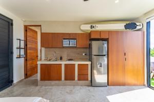 une cuisine avec un réfrigérateur en acier inoxydable et des armoires en bois dans l'établissement Private Jacuzzi, Golf Getaway, sunrise view, à Puerto Aventuras