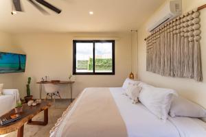 Un dormitorio con una gran cama blanca y una mesa. en Private Jacuzzi, Starlink, Golf-View Terrace - Puerto Aventuras, en Puerto Aventuras