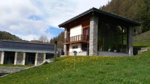 a building on top of a grassy hill next to a building at La Niche B&B in La Thuile