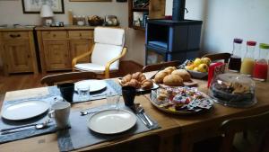 a wooden table with plates and food on it at La Niche B&B in La Thuile +7 photos