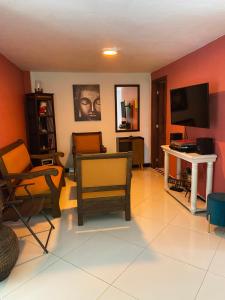 a living room with chairs and a flat screen tv at River house in Jardin