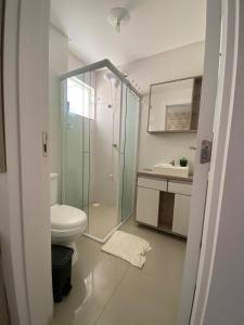 a bathroom with a shower and a toilet and a sink at Apartamento aconchegante a 100 metros da praia! in Porto Belo +4 photos