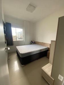 a bedroom with a bed and a window at Apartamento aconchegante a 100 metros da praia! in Porto Belo