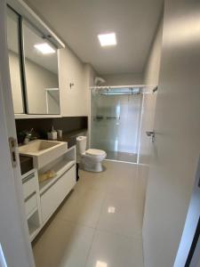 a bathroom with a shower and a toilet and a sink at Apartamento aconchegante a 100 metros da praia! in Porto Belo