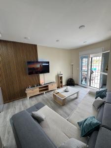 a living room with a couch and a flat screen tv at Appartement charmant avec vue sur la sur mer in Bordj el Bahri
